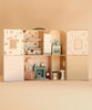 The open Maileg Suitcasa Furnished Set reveals rooms with a bed, kitchen appliances, a miniature armchair with a Maileg mouse, a fireplace, and bathroom fixtures.