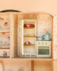 Maileg Suitcasa Furnished Set miniature dollhouse kitchen featuring a refrigerator stocked with food, a stove, and a teapot with a saucepan on top.