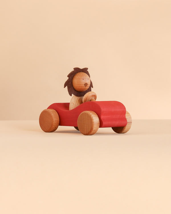 A Sabo Concept Car with Lion featuring a wooden lion driving a red wooden toy car.