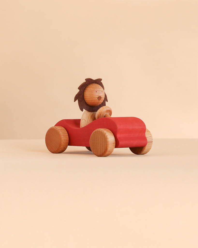 A Sabo Concept Car with Lion featuring a wooden lion driving a red wooden toy car.