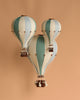 A decorative hot air balloon in mint green and grey hangs against a solid background. This handmade children's room decor features a wooden basket, adding whimsical vintage charm to any space.