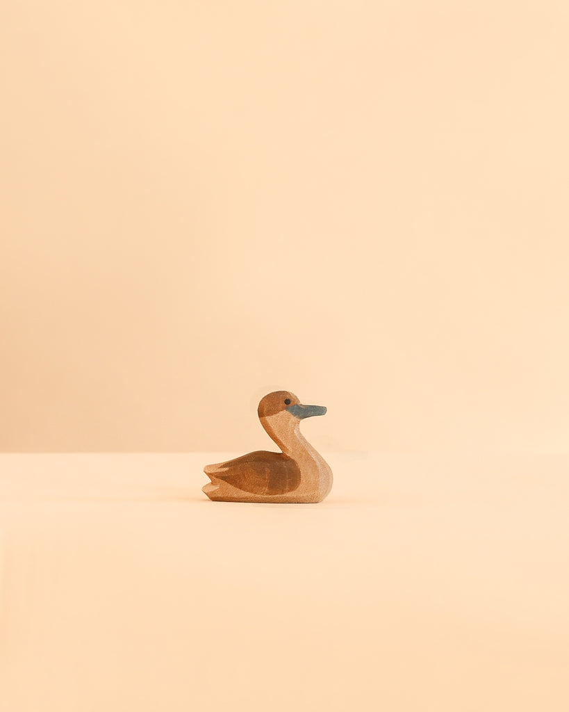 A handcrafted wooden Ostheimer Canada Goose - Small in a resting position, made in Germany.