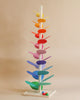 A colorful wooden Giant Magic Wood Marble Tree with flat, elongated paddles in various bright colors, arranged vertically, with wooden marbles at the base ready to descend.