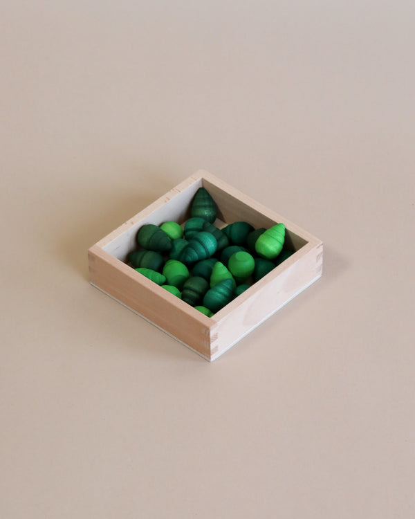 A Grapat small storage box filled with green and blue painted stones arranged neatly on a plain beige background.