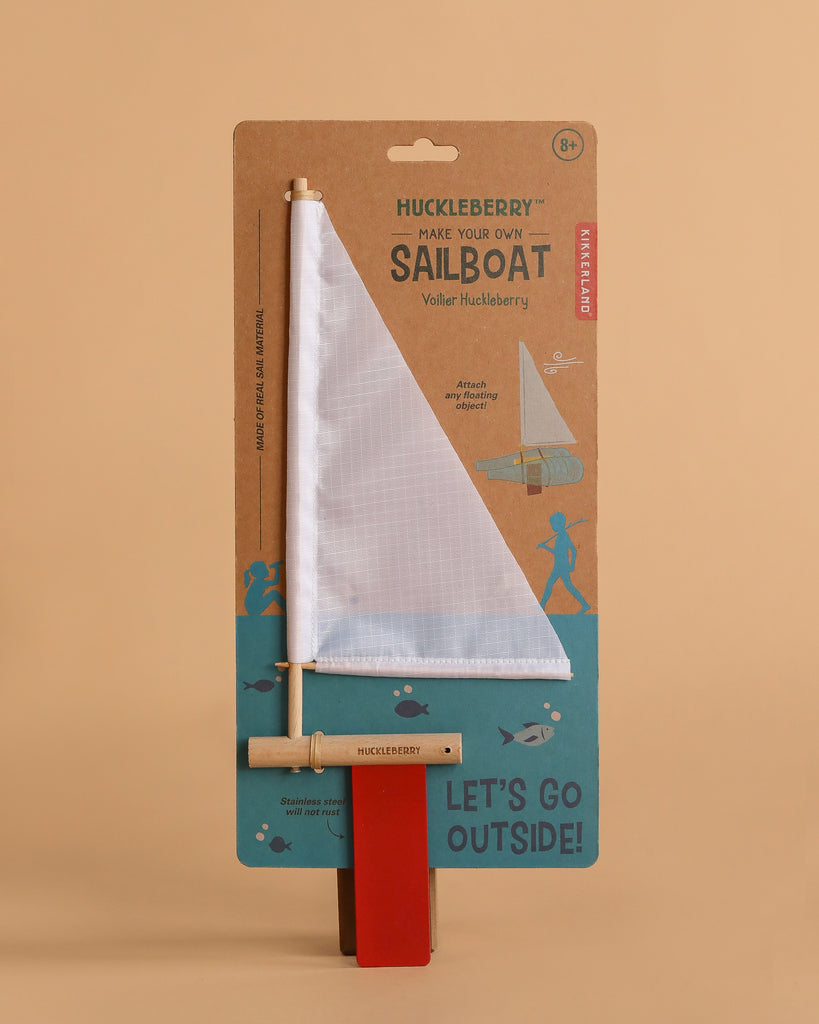 The Huckleberry Make Your Own Sailboat kit includes wooden parts and a white sail, packaged on a brown and teal card with fish, children, and the phrase “Let’s Go Outside!”.