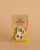 A packaged Huckleberry Dual Magnifier for ages 6+, with a wooden frame, shatterproof 10x lens, and string, is displayed on a tan background. The package says "LET'S GO OUTSIDE!" and features outdoor-themed illustrations.