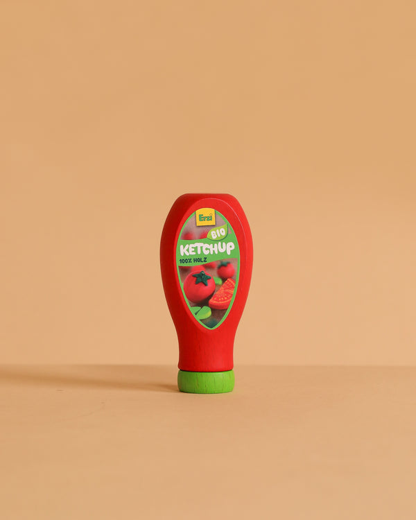 The Erzi Ketchup Pretend Food is a realistic toy bottle with a green cap, standing upright on a beige surface. Non-toxic and ideal for store or kitchen play, it features a tomato label reading "Bio Ketchup.