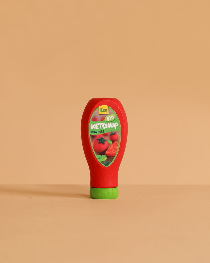 The Erzi Ketchup Pretend Food is a realistic toy bottle with a green cap, standing upright on a beige surface. Non-toxic and ideal for store or kitchen play, it features a tomato label reading "Bio Ketchup.
