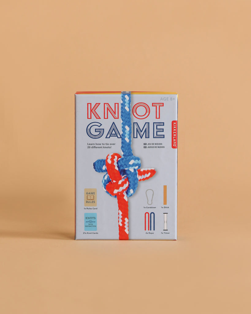 The Knot Game boxed set, shown on a tan background with a colorful knotted rope, teaches over 20 knot-tying skills. Includes game pieces and is designed for ages 8 and up.
