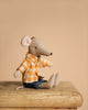 The Maileg Family Theater Set features a stuffed mouse in a yellow plaid shirt and blue pants, sitting on a wooden surface with a plain beige background.