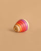 The Mader Wooden Kaleidoscope - Pink is a classic wooden spinning top with colorful pink-themed rings, set against a plain beige background.