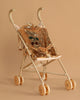 The Konges Sloejd Sparkly Sequin Doll Stroller - Golden Cherry features gold wheels and shiny gold sequin fabric with a cherry design on a matching beige background.