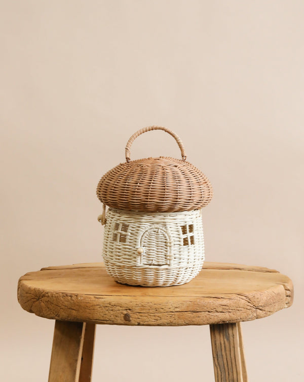 A natural color rattan mushroom basket on a chair. 