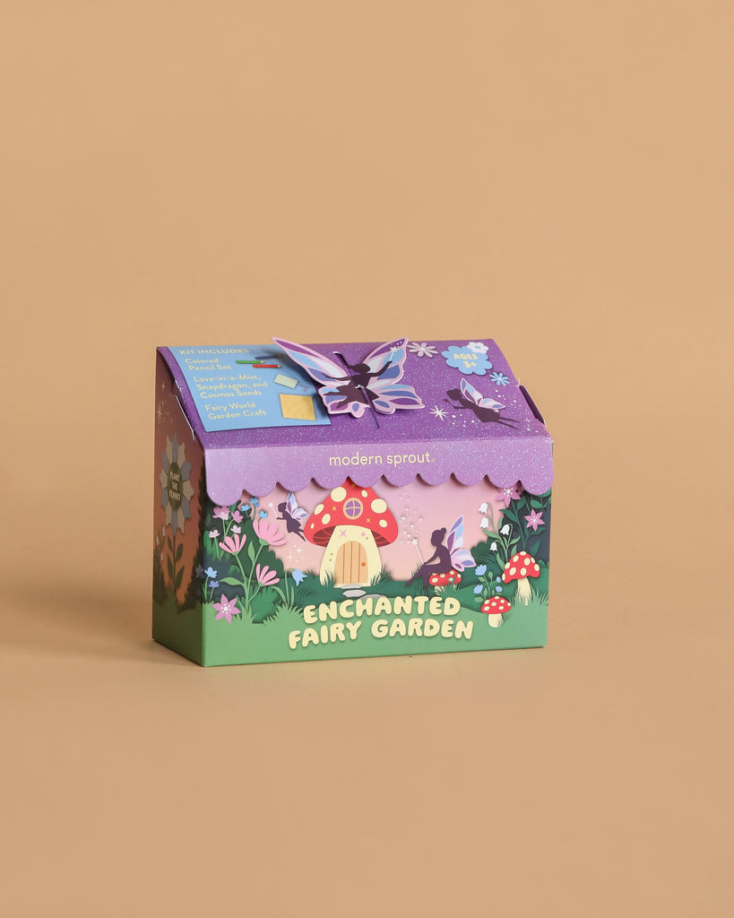 The Magical Minds Garden Kit - Enchanted Fairy Garden comes in a colorful box with whimsical illustrations of a fairy house, mushrooms, flowers, and a purple butterfly on tan—an ideal STEM DIY activity for kids.
