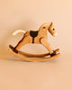 A Spring Copenhagen The Rocking Horse, beautifully crafted from FSC-certified wood with visible wood grains and a smooth finish, stands on a beige background.