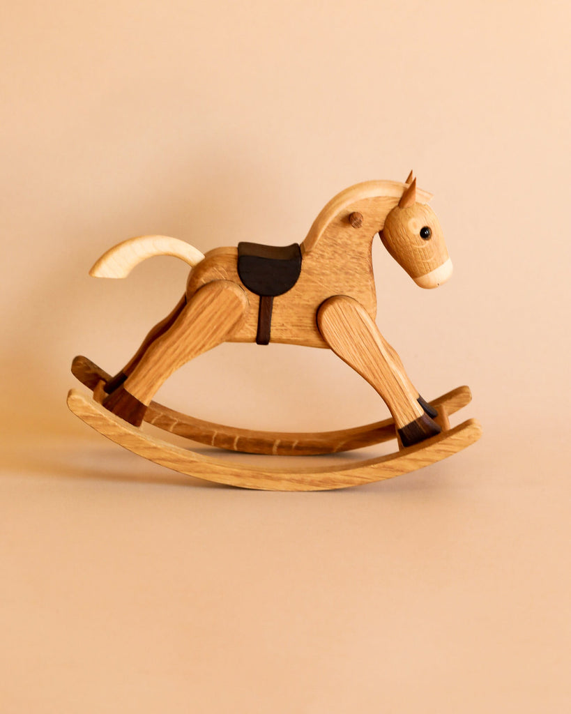 A Spring Copenhagen The Rocking Horse, beautifully crafted from FSC-certified wood with visible wood grains and a smooth finish, stands on a beige background.