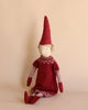A Maileg Small Mrs. Claus (Size: 33 in.) with a pointy red hat, designed as a Christmas decoration, wearing a matching red sweater dress with a white snowflake pattern, striped sleeves, and legs, sitting