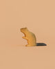 The Bumbu Handmade Wooden Beaver is a small, handcrafted toy with a dark tail, standing upright on a light peach background—perfect for Montessori-inspired play.