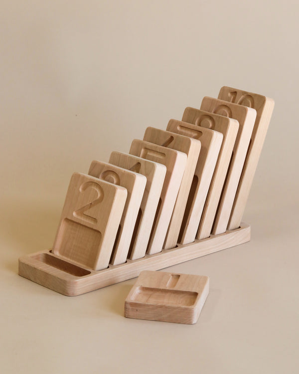 The Original Wooden Counting Trays - Made in USA number blocks from one to eight neatly arranged in a slotted holder on a beige background. The number one block is separated from the others.