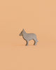The Bumbu Howling Wolf Set features a small, gray wooden figurine of a howling wolf standing upright against a plain light orange background, perfect for imaginative play and crafted from sustainably sourced wood.