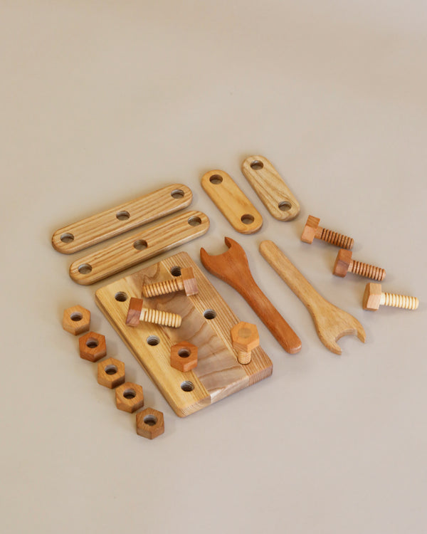 A collection of Handmade Wooden Building Tool Set made from solid ash and beech, arranged on a light surface, including various shapes and sizes designed for different therapeutic purposes.