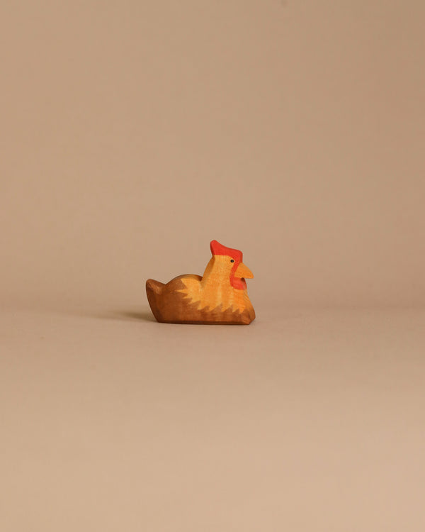 The Ostheimer Hen Brown On Nest is a handcrafted wooden figurine featuring a natural wood finish and a red crest, sitting upright on a simple, beige background, perfect for sparking imaginative play.