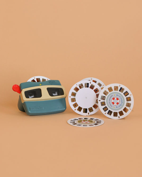 The Sticky Lemon Viewmaster - Wonders of the Deep Sea sits beside three photo reels on a plain beige background, evoking nostalgia and inviting you to explore underwater worlds through its classic viewer.