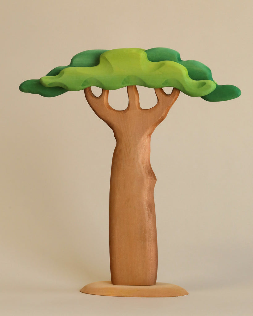 A Extra Large Wooden Tree resembling a tree, crafted from linden wood, with a trunk that seamlessly transitions into exaggerated, rounded branches topped by a flat, green canopy, all set against a neutral background.