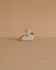 An Ostheimer Handmade Wooden Swan Family Set sits on a flat, beige surface against a matching beige background.