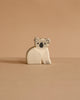 The Ostheimer Koala, a small handcrafted wooden toy painted to resemble a koala, sits on a flat surface with a plain beige background, evoking the timeless charm of classic Ostheimer toys.