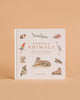 Our Big Book of Animals (Board Book) introduces kids to animal vocabulary with illustrations of a parrot, shark, tiger, rabbit, and owl on a light background set against a peach-colored surface.