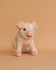 A cute Pig Stuffed Animal with a friendly expression, standing upright on a beige background. The toy is light pink with darker pink inside its floppy ears and a small, open-mouthed smile.