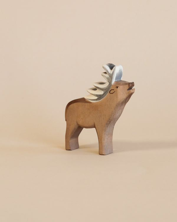 Wooden figurine of a Ostheimer Red Deer - Stag with a metallic, spiral mane against a light beige background. The Ostheimer Red Deer - Stag, an example of handcrafted wooden toys, is crafted with visible wood grains and a painted-on
