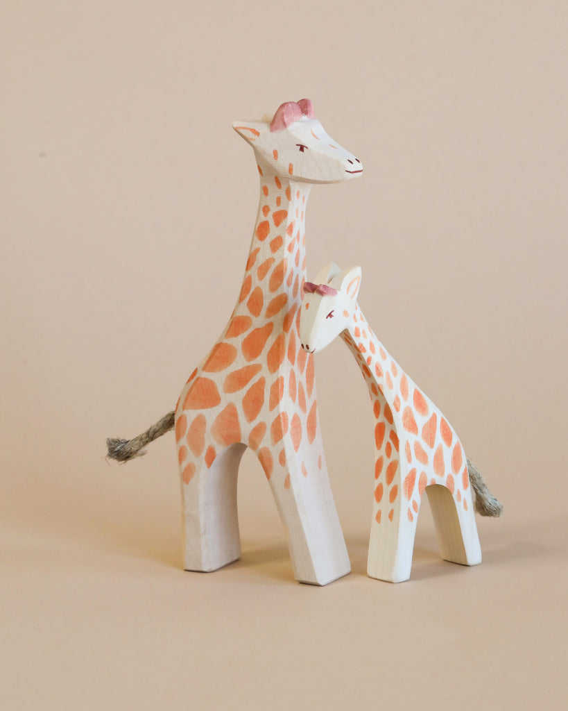 Two Ostheimer Small Giraffe - Head Low figurines, one taller and one shorter, with detailed painted spots, standing against a plain beige background.