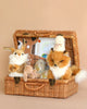 A charming display of realistic plush animals, including a rabbit and a fox, arranged in an Easter Basket Set - Trunk with children's books and Easter eggs, against a soft peach background.