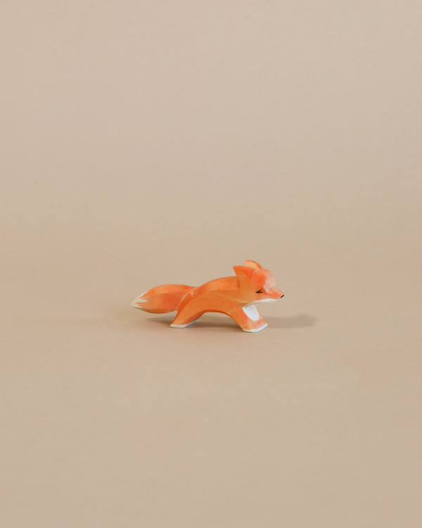 A small, orange Ostheimer Fox - Running figurine on a plain beige background, ideal for imaginative play.