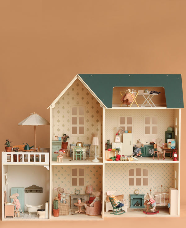The Maileg Fully Furnished Dollhouse Set + Gift With Purchase features multiple rooms, adorable mice figures, and miniature furniture, all arranged in a lively scene against a neutral tan background.