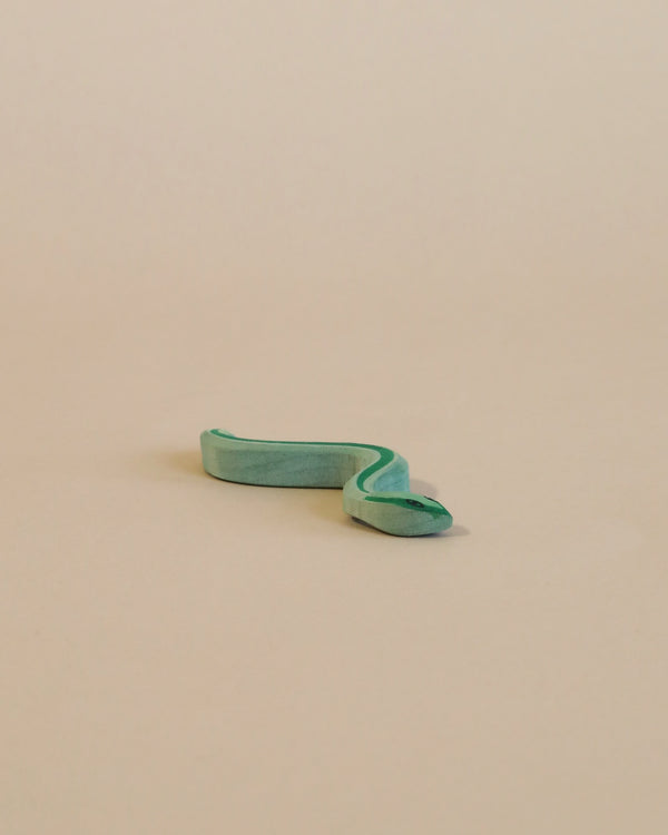 A Ostheimer Snake broken into two pieces, with the smaller piece curved like a snake, set against a plain light beige background, evoking imaginative play.