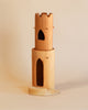Ostheimer Round Tower With Stairs sculpture with a carved castle design, ideal for imaginative play, featuring arched and heart-shaped windows, displayed against a plain beige background.