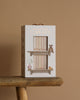 The "Newborn Gift Set - Natural" sits on a wooden stool. Inspired by Cuddle + Kind, the box features book, lamp, teddy bear, and hand-knit baby animal illustrations against a beige background.
