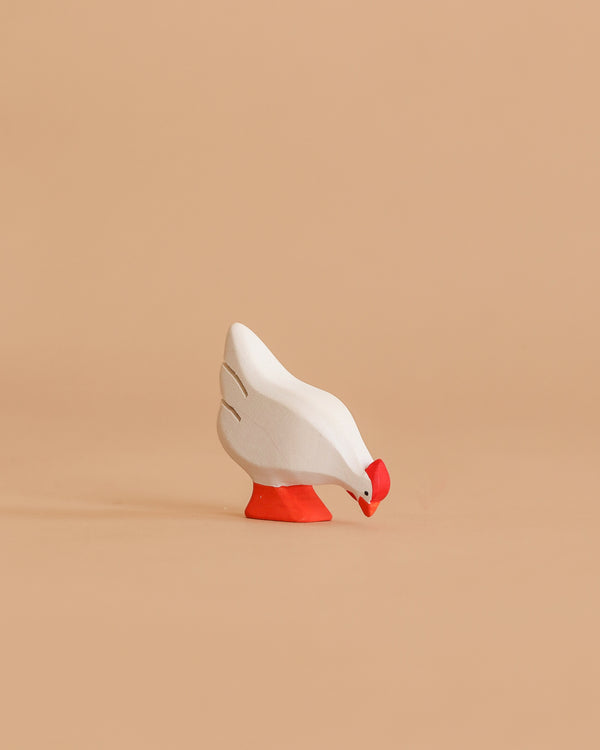 The Bumbu Handmade Wooden White Hen is a small, handcrafted toy with a red beak and feet, beautifully made from sustainable Romanian wood, shown standing on a light brown background.