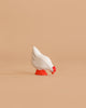 The Bumbu Handmade Wooden White Hen is a small, handcrafted toy with a red beak and feet, beautifully made from sustainable Romanian wood, shown standing on a light brown background.