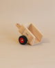 The Maileg x Fagus Limited Edition Tractor Set features a minimalist tractor with a single black and red wheel, displayed on a beige surface that highlights its collector's item appeal.