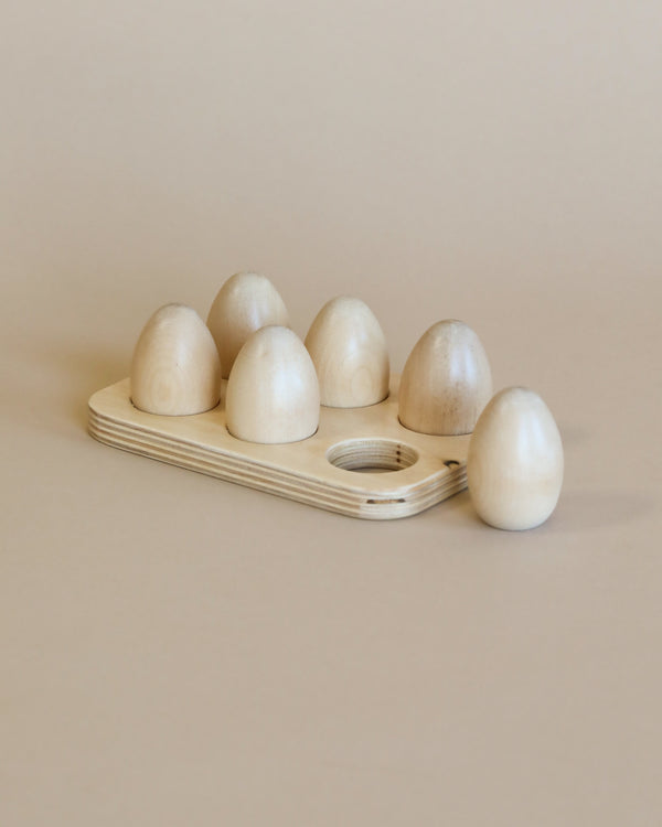 A set of unpainted wooden half dozen eggs, each half displayed in a neat, organized arrangement on a neutral background. The largest piece has a subtle, metallic sheen reminiscent of Amish crafted toys.