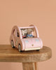 Two small plush mice in striped shirts sit inside the Maileg Road Trip Adventure Set’s wooden toy car with floral details, arranged on a wooden table against a peach backdrop—a delightful addition to any dolls house.