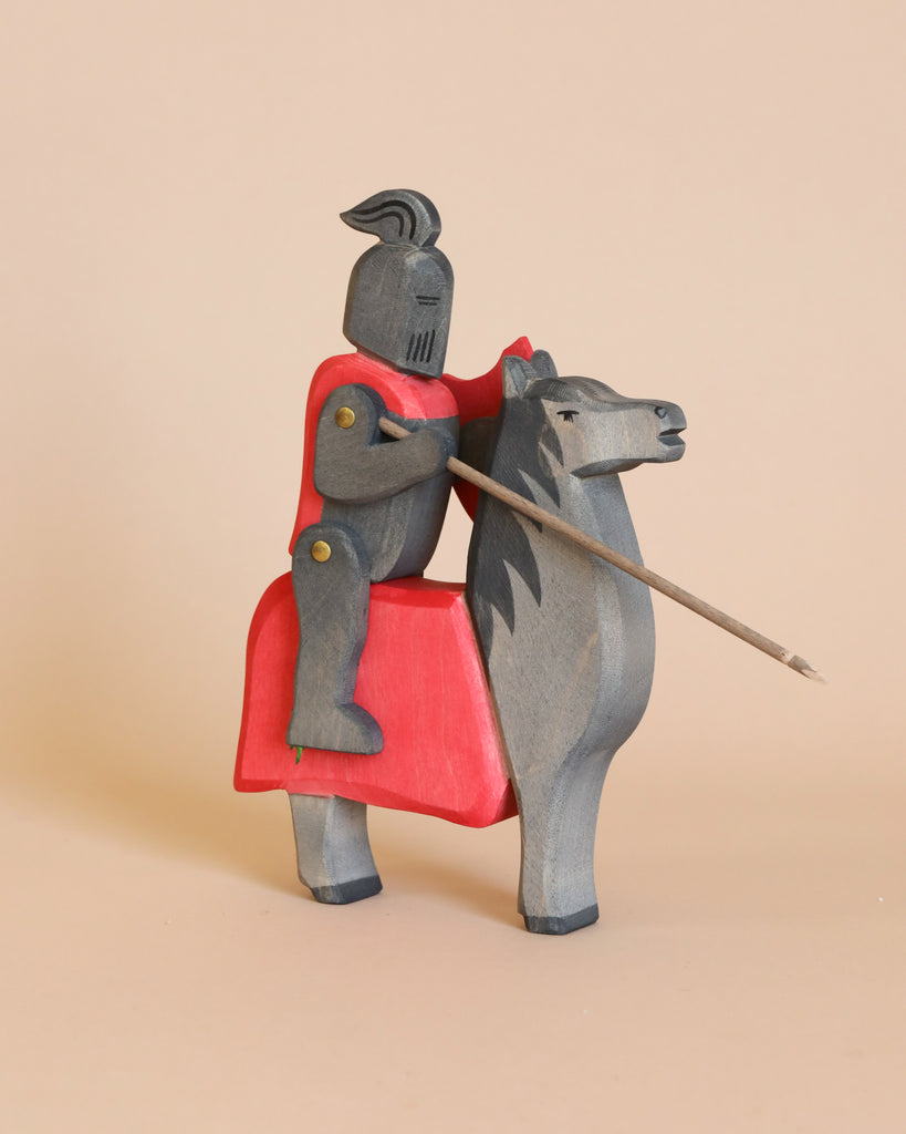 Experience the charm of the Ostheimer brand with this handcrafted wooden figurine, "Ostheimer Horse for Black Knight." This medieval knight in black armor, adorned with a red cape, is mounted on a gray horse featuring a striking red saddle. Perfect for imaginative play, the knight wields a lance and has movable joints, effortlessly capturing timeless craftsmanship.