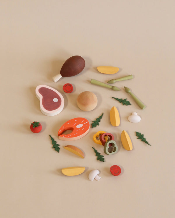 Various Sabo Concept Handmade Wooden Dinner Set items including fruits, vegetables, eggs, and meat pieces, all coated in non-toxic paint and neatly arranged on a light beige background.