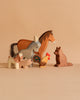 The Ostheimer Handmade Wooden Farm Animals Set, featuring a horse, donkey, fox, pig, goat, and rooster, is displayed on a beige surface with a neutral background. These handcrafted toys bring charm to any playroom.