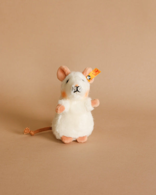 A plush toy resembling a Pilla Mouse Stuffed Plush Animal by Steiff with high quality woven fur stands upright against a solid beige background, featuring large eyes and a bushy tail.