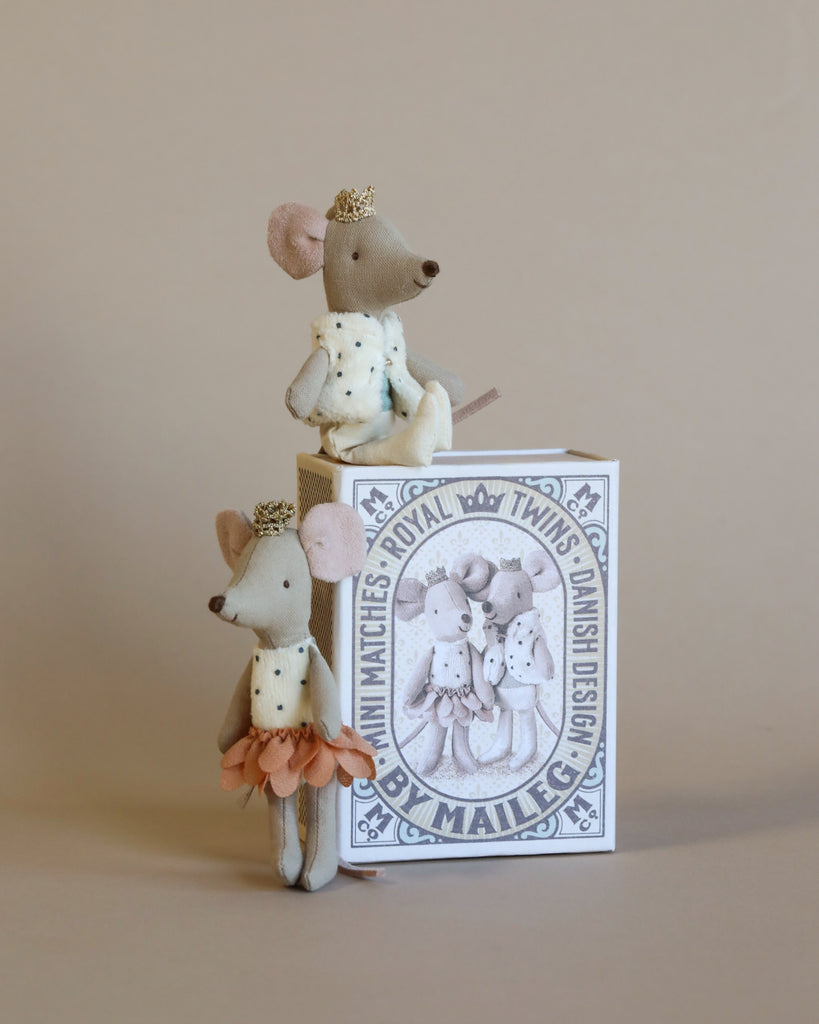 Three handmade Royal Twins in a Box dolls, one sitting atop a customized matchbox, another leaning against it, and the third standing beside it, all dressed in fabric outfits including a plush dotted vest against a neutral background.